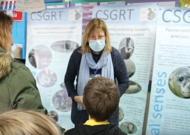 Photo showing SRT banners and volunteer talking to pupils