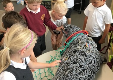 Photos showing children handing a life size ghost gear seal