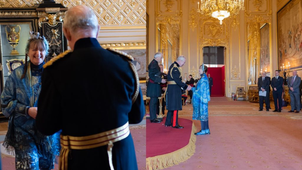 Photo of Sue Sayer MBE walking up to King Charles and shaking his hand
